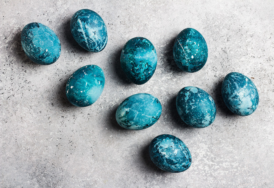 Easter eggs painted by hand in blue color on light background